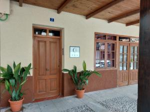ein Gebäude mit einer Holztür und zwei Topfpflanzen in der Unterkunft CON ENCANTO in Cabezuela del Valle
