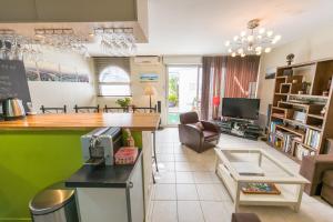 a kitchen and living room with a bar and a couch at Appt 75m2 port St-Martin, parking inclus in Saint-Martin-de-Ré