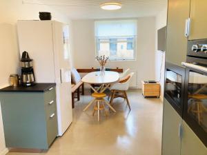 a kitchen and dining room with a table in a room at Villa med private værelser delt badeværelse/køkken, viby sj. in Viby