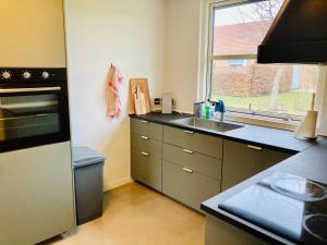 een keuken met een aanrecht, een wastafel en een raam bij Villa med private værelser delt badeværelse/køkken, viby sj. in Viby