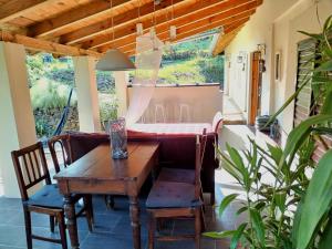 a porch with a wooden table and chairs and a dining room at Levendula Vendèghàz in Zalaszentgrót