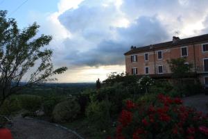 a building on a hill with flowers in front of it at B&B La Casetta in Carbonara Scrivia