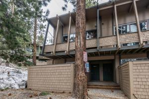 a building with a balcony in the woods at Tyrolean Village 6 2 Bedroom 1 and a Half Bath Sleeps 6 Walk to Lift Steps to town shuttle in Mammoth Lakes