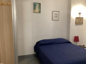 een slaapkamer met een blauw bed en foto's aan de muur bij Il nido di Pietro in Verano Brianza