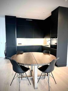 a kitchen with a table and chairs in a room at Vervet apartment in Tromsø