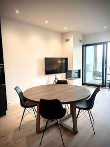 a table in a room with chairs and a television at Vervet apartment in Tromsø
