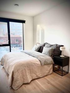 1 dormitorio con cama y ventana grande en Vervet apartment en Tromsø