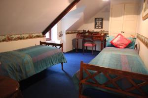 a attic room with two beds and a desk at Manoir du Mur in Comblessac