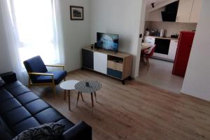 un soggiorno con un divano, un tavolo e una cucina di Cute Apartment Marla Art close to Center a Pola (Pula)