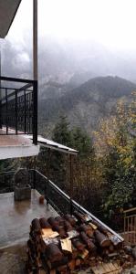 a pile of fire wood on a balcony of a mountain at The log house in the village in Pramanta