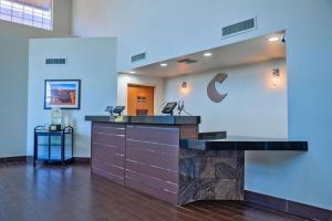 Comfort Inn & Suites Sierra Vista near Ft Huachuca في سييرا فيستا: لوبى مع مكتب استقبال مع شعار شركة c على الحائط