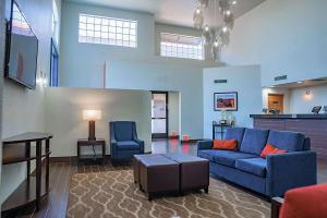 ein Wohnzimmer mit einem blauen Sofa und einem Tisch in der Unterkunft Comfort Inn & Suites Sierra Vista near Ft Huachuca in Sierra Vista