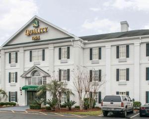 a white building with a sign that reads quality inn at Quality Inn Lake City in Lake City