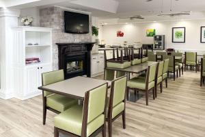 a dining room with tables and chairs and a fireplace at Quality Inn Richmond in Richmond