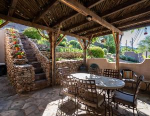 a patio with a table and chairs and a stone wall at Harmony House, 3 Bedrooms, 2 wood fireplaces, 3 patios in Santa Fe