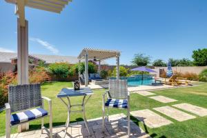 un patio trasero con sillas, una mesa y una pérgola en Chandler Home with Pool, Remote Workers Welcome!, en Chandler