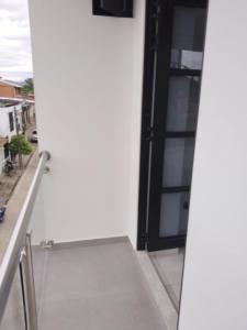 eine offene Tür zu einem weißen Gebäude mit Balkon in der Unterkunft Apartamento 302 Yopal in Yopal