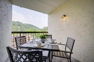 a dining room with a table and chairs on a balcony at Stylish Gatlinburg Condo with Pool Walk Downtown! in Gatlinburg
