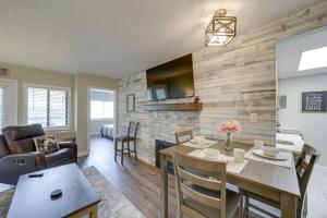 a dining room and living room with a table and chairs at Stylish Gatlinburg Condo with Pool Walk Downtown! in Gatlinburg