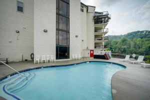 a large swimming pool in front of a building at Stylish Gatlinburg Condo with Pool Walk Downtown! in Gatlinburg