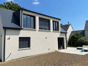 a white house with black windows and a driveway at La résidence du Franc Palais 2 in Joue-les-Tours