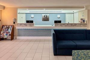 a lobby with a waiting area with a blue couch at Quality Inn Nacogdoches Near University in Nacogdoches