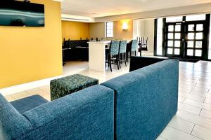 una hall con divano blu, tavoli e sedie di Quality Inn Nacogdoches Near University a Nacogdoches