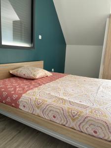 a bedroom with a bed with a bedspread and a pillow at La résidence du Franc Palais 2 in Joue-les-Tours