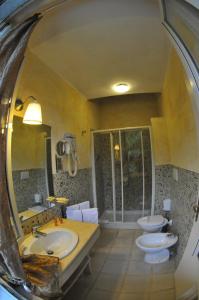 La salle de bains est pourvue de 2 lavabos, de toilettes et d'un miroir. dans l'établissement Hotel Atlantic, à Marina di Carrara