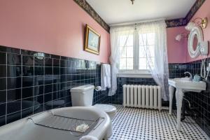 a bathroom with a tub and a toilet and a sink at Chestnut Inn in Niagara Falls +37 photos
