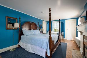 a bedroom with a large bed with blue walls at Chestnut Inn in Niagara Falls