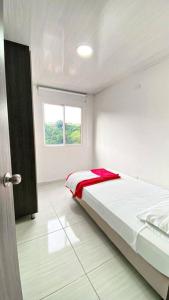 a bedroom with a bed with a red blanket on it at Apartahotel 222 Apartamento 503 in Pereira
