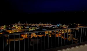 een balkon met uitzicht op een haven in de nacht bij Apartments Maris in Baška Voda