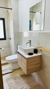 Un baño con lavabo, inodoro y espejo. en F4 - chic - piscine - salle fitness, en Dakar