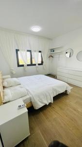 1 dormitorio con 1 cama blanca grande y 2 ventanas en F4 - chic - piscine - salle fitness en Dakar