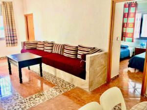 a living room with a red couch and a table at Blue holiday in Oued Laou