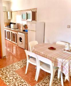 een keuken met een tafel en stoelen en een koelkast bij Blue holiday in Oued Laou
