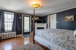 sypialnia z niebieskimi ścianami, łóżkiem i kominkiem w obiekcie Chestnut Inn w mieście Niagara Falls
