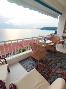 a balcony with chairs and a table and the water at Cozy Seaview Apartment in Siviri