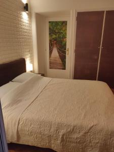 a bedroom with a bed and a painting of a bridge at Athens Riviera apt with seaview, 15' to Acropolis in Athens