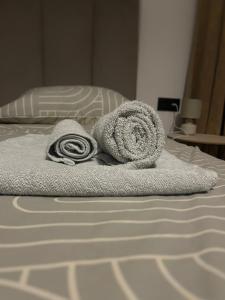 a pile of towels sitting on a bed at Rooms 10 mins walk from train station! in Agualva