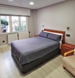 um quarto com uma cama grande e almofadas roxas em El Manso, 150m Playa, Opción de Garaje em Gijón
