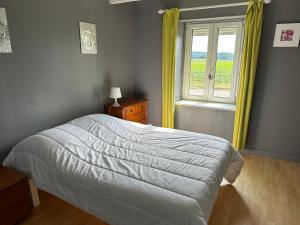 Schlafzimmer mit einem Bett und einem Fenster in der Unterkunft La maison du chêne 3 in Miniac-Morvan