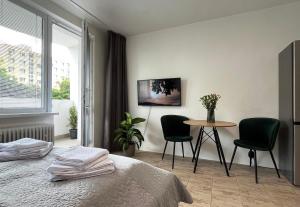 a bedroom with a bed and a table and chairs at New cozy studio, private parking in Bratislava