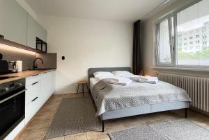 a small bedroom with a bed and a kitchen at New cozy studio, private parking in Bratislava