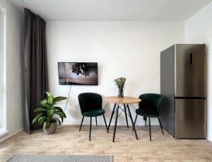 uma cozinha com uma mesa e cadeiras e um frigorífico em New cozy studio, private parking em Bratislava