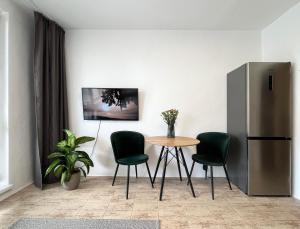 a kitchen with a table and chairs and a refrigerator at New cozy studio, private parking in Bratislava