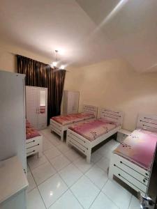 a bedroom with three beds and a window at Moca hostel in Dubai