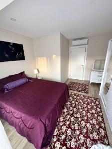 a bedroom with a purple bed and a rug at Antalya Lara Dubleks 2+1 in Altınkum