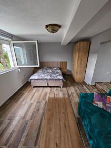a bedroom with a bed and a wooden floor at City View Apartment in Bijelo Polje